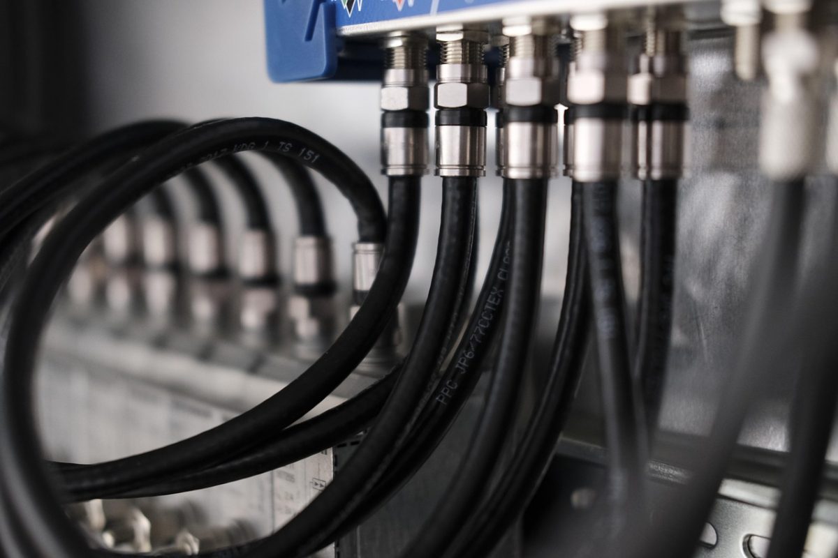 Person troubleshooting a TV displaying a No Signal message by checking cables and inputs.